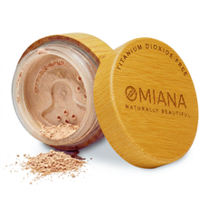 Open container of Omiana Mineral Loose  Powder Makeup for sensitive skin with visible brand name on a white background