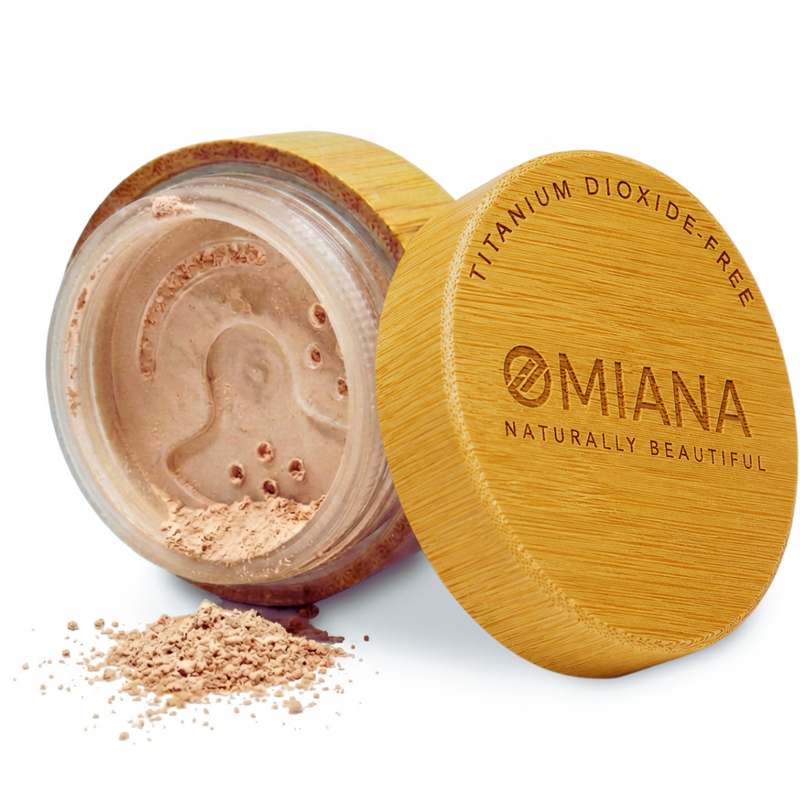 Open container of Omiana Mineral Loose  Powder Makeup for sensitive skin with visible brand name on a white background